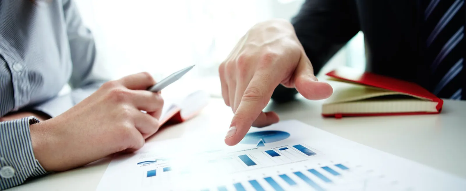 Two people reviewing charts on a printed report